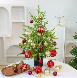 Detailed view of a table-top PE Christmas tree with red and gold festive ornaments