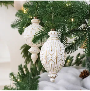 Detailansicht von antiken weiß-goldenen Weihnachtsschmuck-Anhängern an einem Baum.