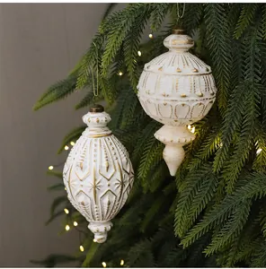 Elegante weiße und goldene Vintage-Weihnachtskugeln an einem grünen Weihnachtsbaum.