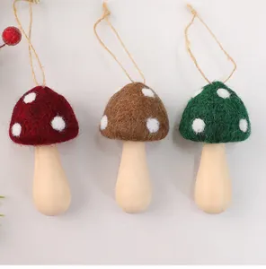 Three handcrafted wool felt mushroom Christmas tree ornaments with wooden stems and strings