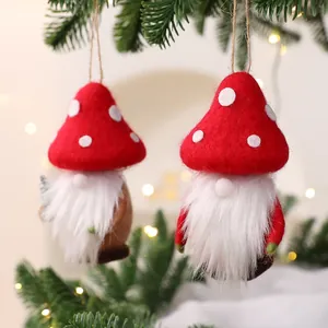 Felt mushroom Christmas gnome ornaments hanging on a festive pine tree branch