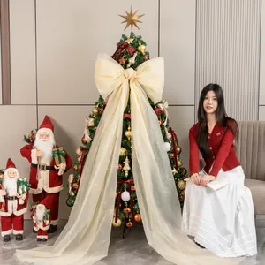 Elegante kerstboomset met een enorme crème strik voor een feestelijke huisdecoratie