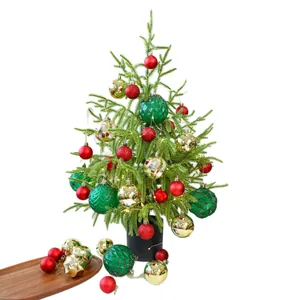 Tabletop Christmas tree set with red, green, and gold ornaments on white background.
