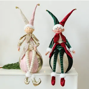 Detailansicht festlicher Weihnachts-Elfpuppen mit Paillettenmützen auf Kugeln sitzend.