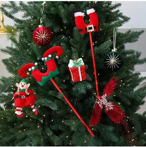 Detalle de adornos para árbol de Navidad con piernas de elfo y temas de Papá Noel.
