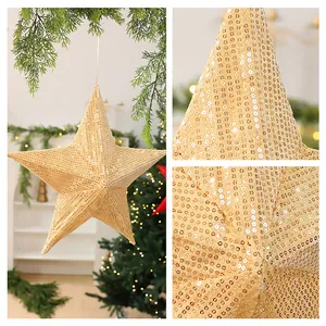 Macro detail of gold sequined star Christmas tree ornament in warm holiday setting.