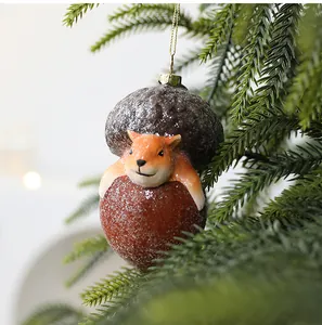 Detailopname van een schattig vosornament in eikelvorm aan een kerstboomtak
