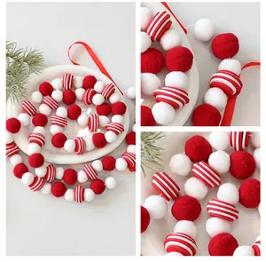 Détail de la guirlande festive de pompons en feutre rouge et blanc pour sapin de Noël