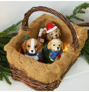Gros plan de trois adorables figurines de chiots de Noël en résine dans un panier rustique