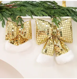 Dettaglio di fiocchi di Natale a specchio disco dorati con bordo in peluche bianco su ramo.