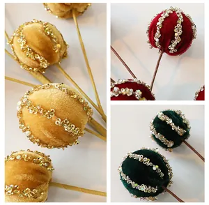 Dettaglio di rami con palline di Natale in velluto e decorazioni di paillettes.