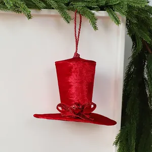 Gros plan d'une décoration de Noël en forme de mini haut-de-forme en velours rouge à nœud.
