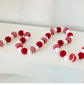 Vue détaillée d'une guirlande de boules en feutre de lana rouge et blanche