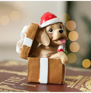 Gros plan d'un chiot en résine dans une boîte cadeau de Noël avec un sucre d'orge