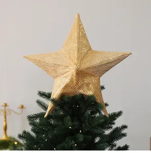 Detailed shot of a large gold sequin star topper on a green Christmas tree.