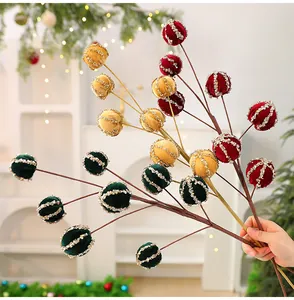 Dettaglio rami di bacche di Natale floccate con palline glitterate per decorazione