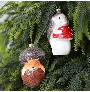 Schattige egel en vos kerstornamenten hangend aan een feestelijke kerstboom