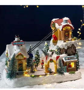 Detailed view of a glowing Christmas ski resort miniature with cable cars and LED lights.