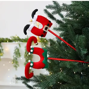 Primer plano de piernas de Papá Noel y elfo de peluche en un árbol de Navidad