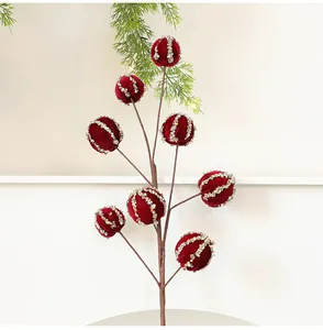 Dettaglio del ramo con palline di Natale in velluto rosso e strisce di paillettes