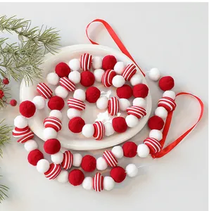 Détail d'une guirlande de boules en feutre rouge et blanc pour décoration de Noël.