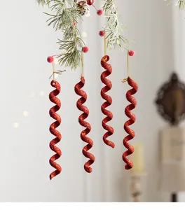 Adornos navideños de espiral de hielo rojo brillante colgados de una rama de pino