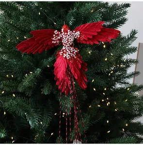 Primo piano di un colibrì in velluto rosso decorato con perle su un albero di Natale.