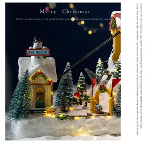 Detail showing a miniature Christmas ski resort music box with warm glowing lights.