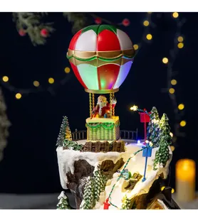 Detail view of a Christmas village music box featuring Santa Claus in a hot air balloon