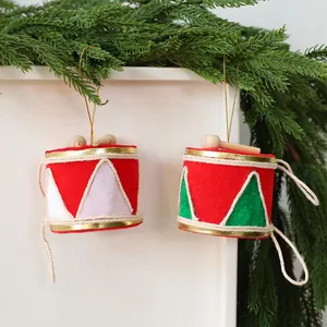 Vue détaillée de suspensions de tambour de Noël festives en feutre rouge avec bordure dorée