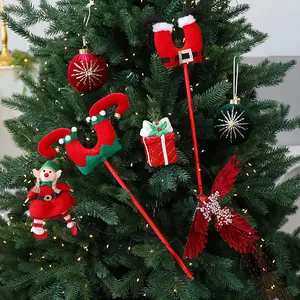 Piernas de elfo festivas y adornos de peluche decorados en un árbol de Navidad