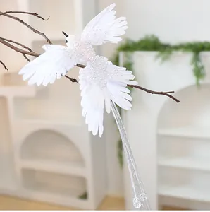 Vista dettagliata di un ornamento natalizio a forma di colibrì bianco con paillettes.