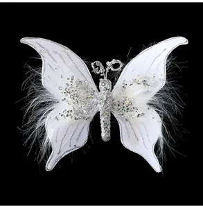Detailopname van een witte stoffen vlinder met zilveren pailletten en zachte veren.