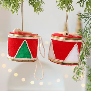 Ornements de tambour de Noël rouges suspendus à des branches de pin pour la décoration