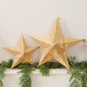 Detail of large and small gold sequin folding stars on a festive pine branch display