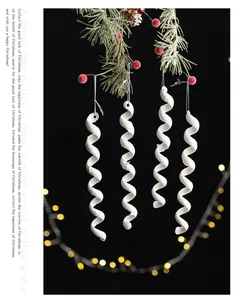 Detalle de cuatro adornos de espiral blanca con purpurina para el árbol de Navidad
