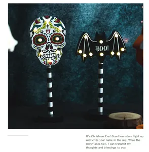 Nahaufnahme von Halloween LED Totenkopf und Fledermaus Holzleuchten im Dunkeln