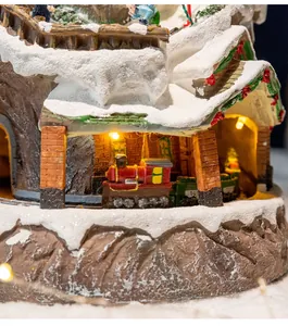 Close-up detail of Christmas village music box with a red train and warm LED lights.