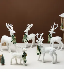 Collezione di renne bianche floccate con fiocchi verdi e campanelli per decoro natalizio