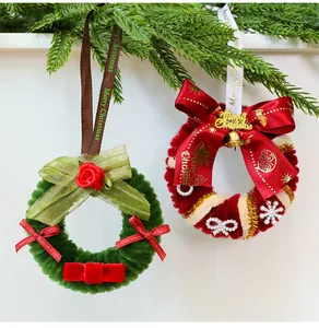 Detalle de coronas navideñas de chenilla tejidas con lazos y cascabeles