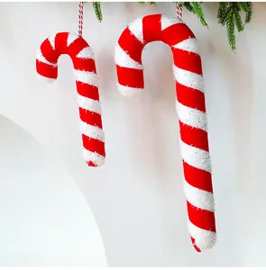Close-up of red and white striped Christmas candy cane hanging decorations with glitter