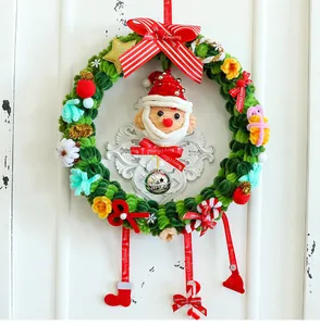 Primer plano de una corona de Navidad hecha a mano de 27 cm con decoro de Papá Noel