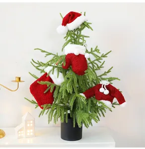 Detail van rood-witte pluchen kerstversieringen zoals mutsen en sokken aan een boom