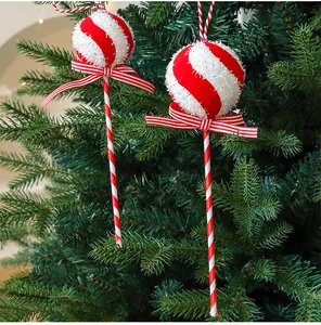 Detail of red and white striped candy lollipop ornament on a green Christmas tree