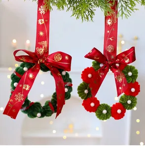 Primer plano de coronas de Navidad DIY hechas a mano con cintas rojas de Feliz Navidad