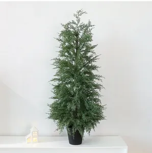 Lush green artificial cypress Christmas tree in a sleek black pot on a white surface