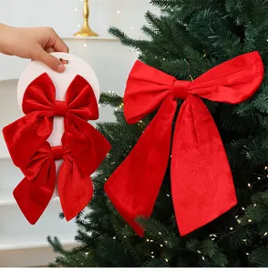 Large red velvet Christmas bow ornaments displayed on a tree for festive home holiday decor