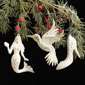 Adornos navideños vintage blancos con motivos de sirène, pájaro y zapato de tacón.