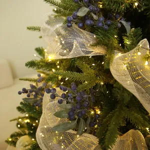 Festive artificial blueberry picks decorating a Christmas tree with warm lights