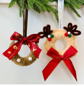Detalle de dos coronas de Navidad DIY hechas a mano con limpiapipas y lazos rojos